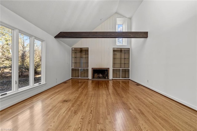 unfurnished living room featuring a brick fireplace, light hardwood / wood-style flooring, and lofted ceiling