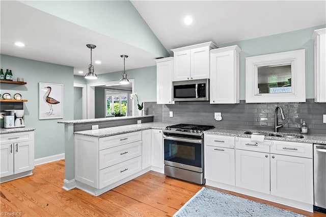 968 Avon Rd, Winston-Salem, NC 27104 - kitchen with appliances with stainless steel finishes, a sink, a peninsula, white cabinetry, and decorative backsplash