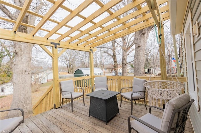 wooden terrace featuring a storage shed and a pergola