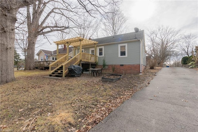 back of house featuring a wooden deck and a pergola