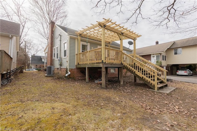 back of property featuring a deck, central AC unit, and a pergola