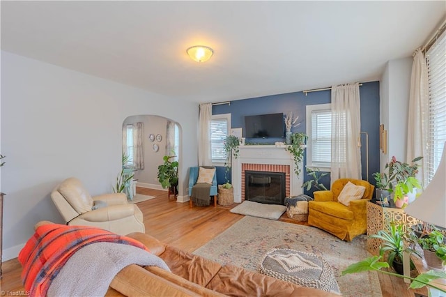 living room featuring hardwood / wood-style flooring and a brick fireplace