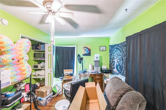 bedroom featuring wood finished floors, ceiling fan, and a textured ceiling