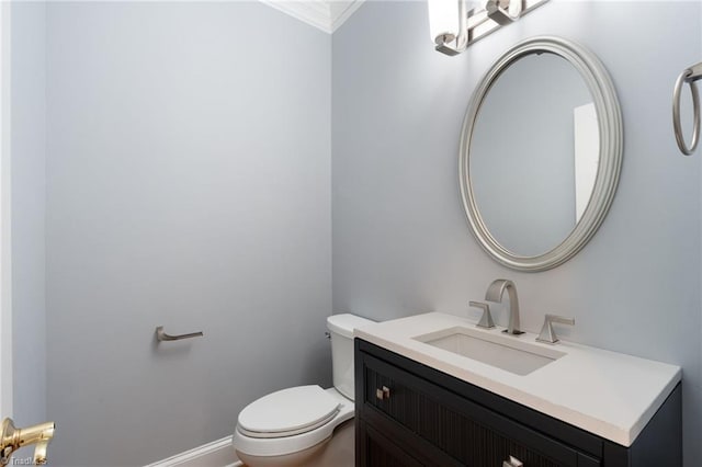 bathroom featuring crown molding, vanity, and toilet