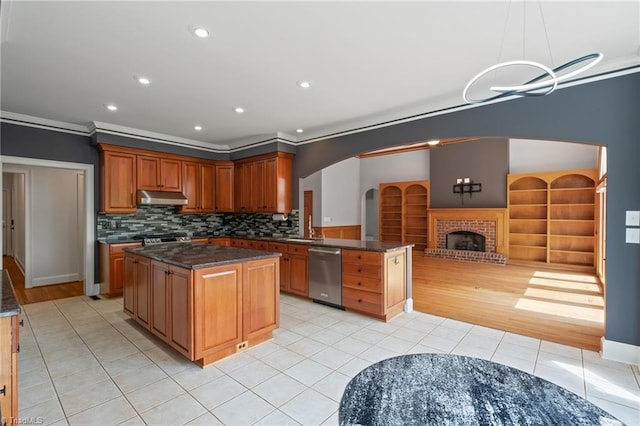 kitchen featuring light tile patterned flooring, open floor plan, stainless steel dishwasher, under cabinet range hood, and ornamental molding