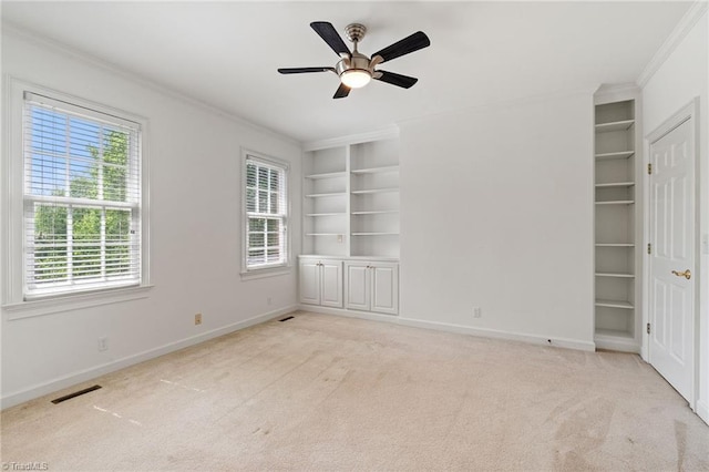 unfurnished bedroom featuring crown molding, multiple windows, carpet flooring, and visible vents