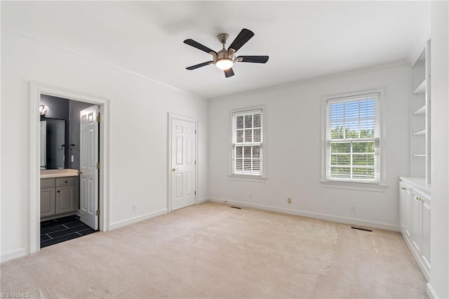 unfurnished bedroom featuring crown molding, baseboards, and light carpet