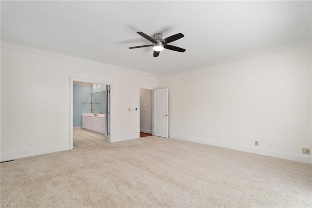 spare room featuring crown molding, a ceiling fan, carpet flooring, and baseboards