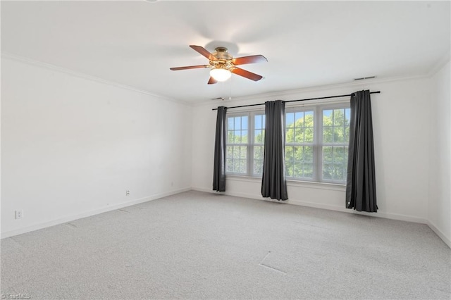 spare room featuring ornamental molding, a ceiling fan, and light carpet