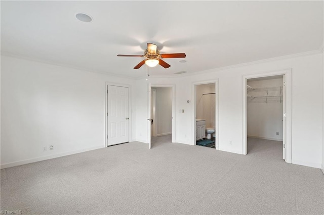 unfurnished bedroom featuring crown molding, connected bathroom, and carpet