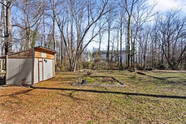 view of yard with a storage shed, a garden, and an outbuilding