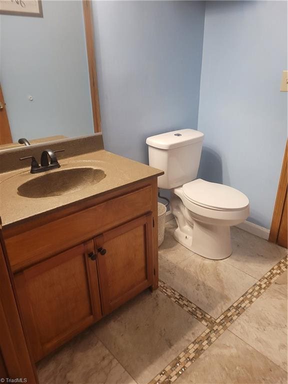 bathroom featuring tile patterned floors, vanity, and toilet