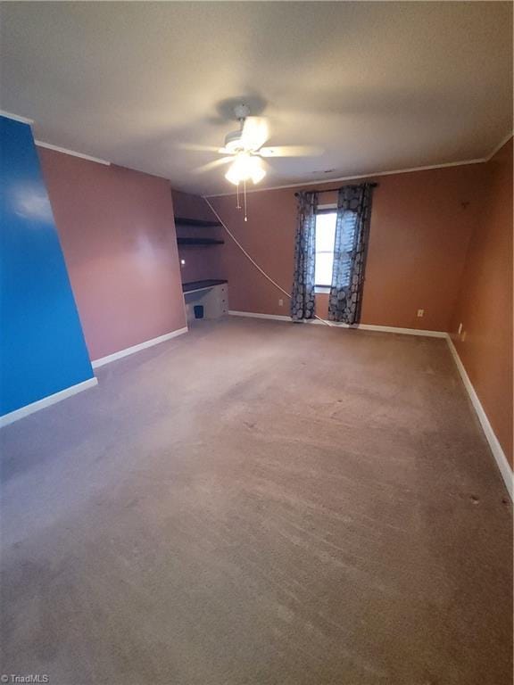 carpeted empty room featuring ceiling fan and ornamental molding