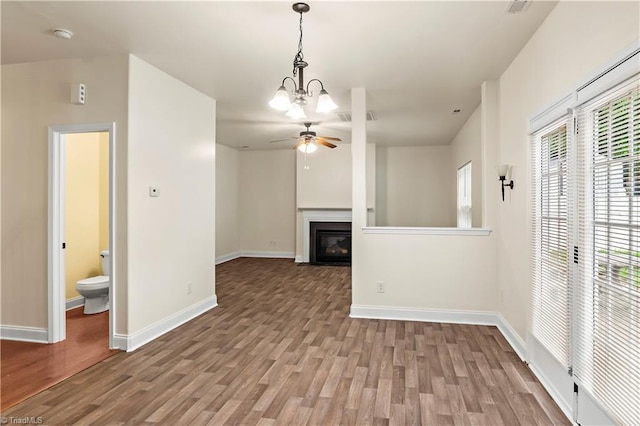 1771 Timber Cove Ct, Winston-Salem, NC 27127 - unfurnished living room featuring ceiling fan, wood finished floors, baseboards, a glass covered fireplace, and a chandelier