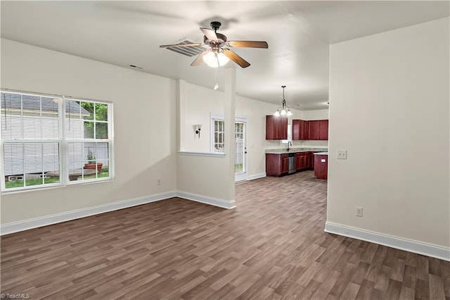 1771 Timber Cove Ct, Winston-Salem, NC 27127 - unfurnished living room with dark wood-style floors, a ceiling fan, a sink, baseboards, and a chandelier
