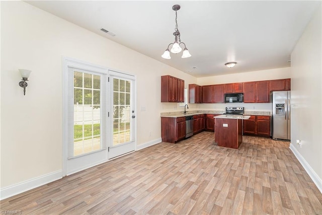 1771 Timber Cove Ct, Winston-Salem, NC 27127 - kitchen with appliances with stainless steel finishes, light wood finished floors, light countertops, and a chandelier