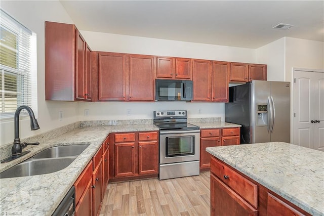 1771 Timber Cove Ct, Winston-Salem, NC 27127 - kitchen with stainless steel appliances, a sink, reddish brown cabinets, light wood-type flooring, and light stone countertops