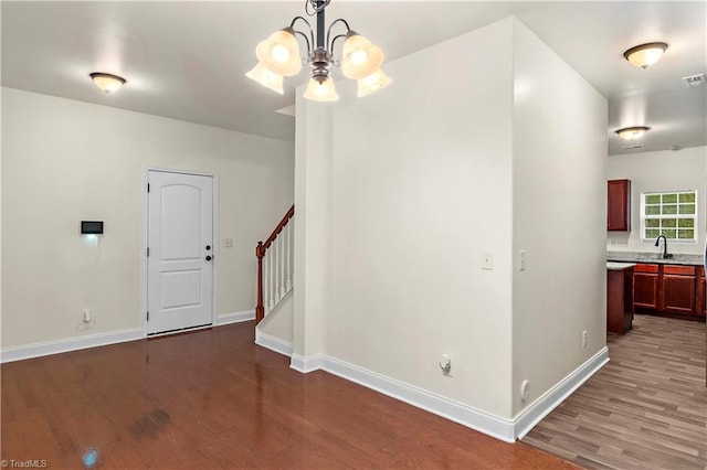 1771 Timber Cove Ct, Winston-Salem, NC 27127 - empty room with wood finished floors, baseboards, stairway, a chandelier, and a sink