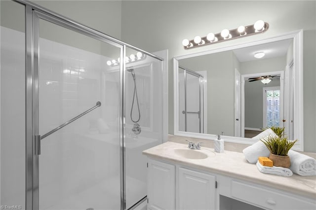 bathroom featuring a shower with door, vanity, and ceiling fan