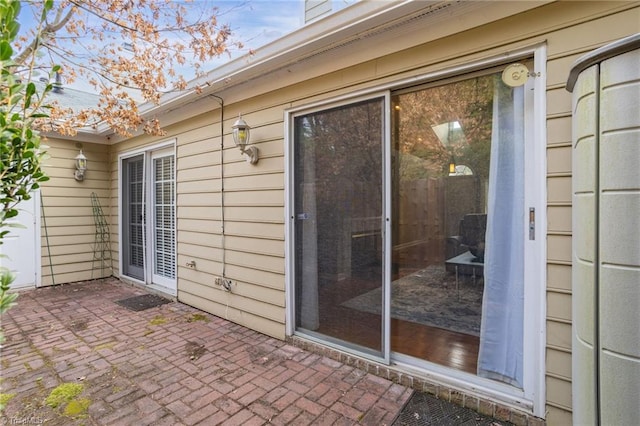 view of exterior entry with a patio area