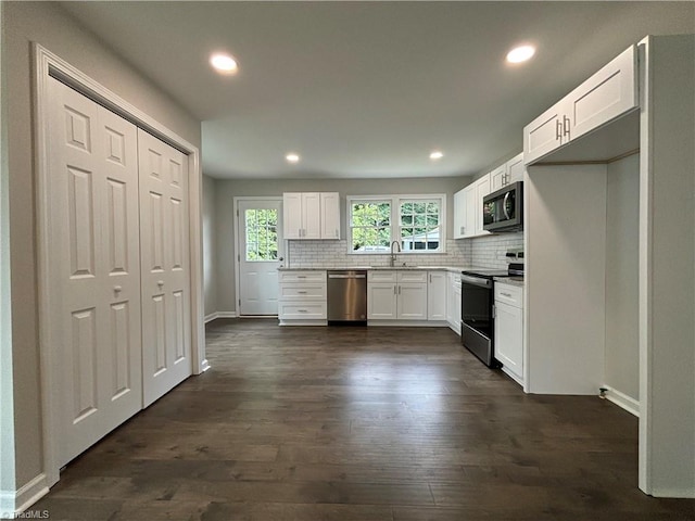 kitchen with stainless steel appliances, sink, decorative backsplash, dark hardwood / wood-style floors, and white cabinets