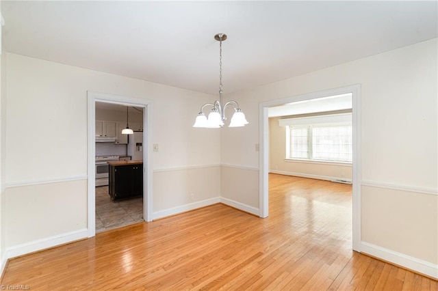 unfurnished dining area with hardwood / wood-style flooring and a chandelier