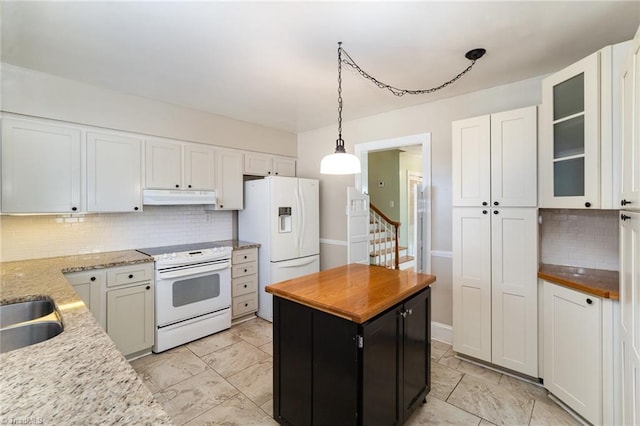 kitchen featuring white appliances, decorative backsplash, and white cabinets