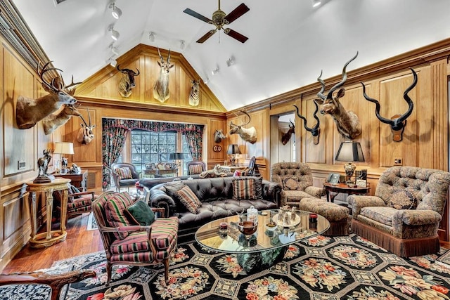 living room with wood-type flooring, high vaulted ceiling, wooden walls, and track lighting