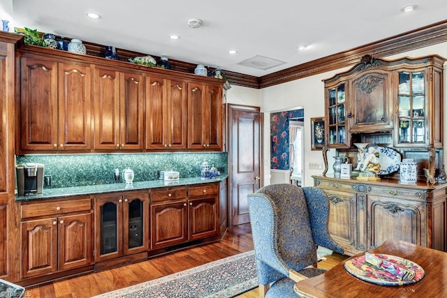 kitchen featuring hardwood / wood-style flooring, crown molding, and backsplash