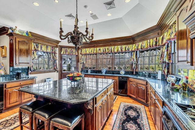 kitchen with light hardwood / wood-style flooring, a notable chandelier, lofted ceiling, and a center island