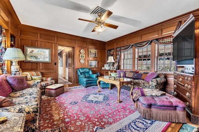 living room featuring wooden walls, ceiling fan, and hardwood / wood-style floors