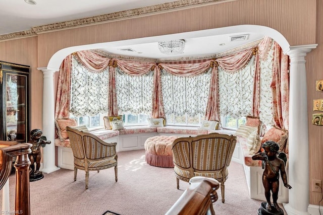 living area with decorative columns, a healthy amount of sunlight, and light colored carpet