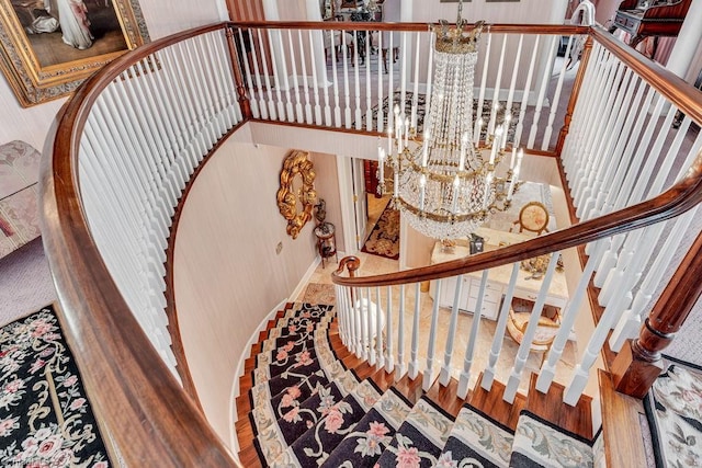 stairs with hardwood / wood-style floors and a chandelier