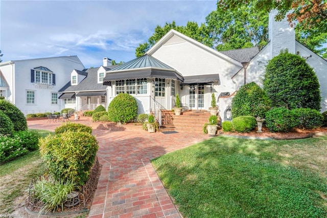 view of front of house with a front yard and a sunroom