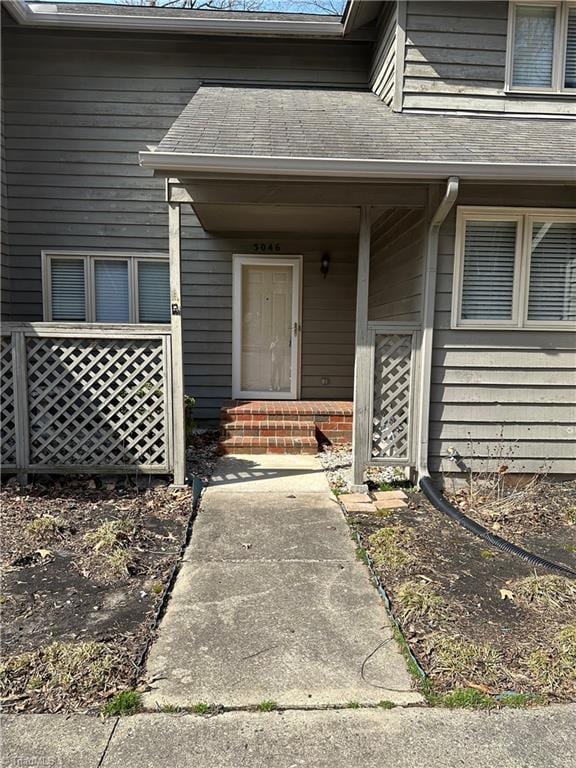 property entrance featuring roof with shingles