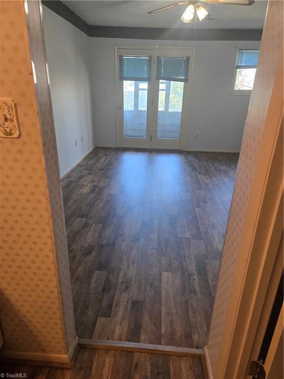 spare room featuring baseboards, wood finished floors, and a ceiling fan