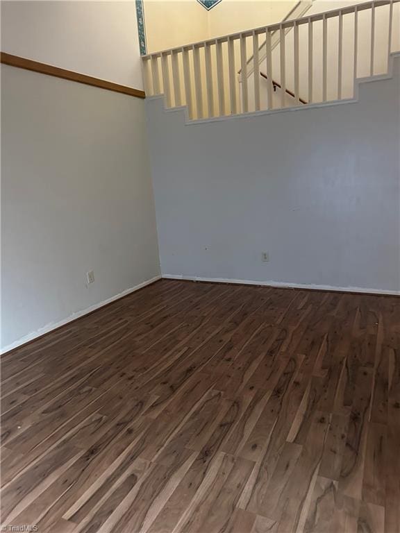 spare room with dark wood-style flooring