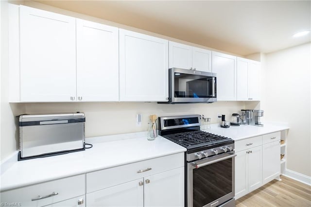 kitchen with white cabinets, stainless steel appliances, and light countertops