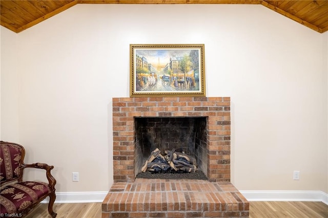 room details featuring a brick fireplace, wood ceiling, baseboards, and wood finished floors