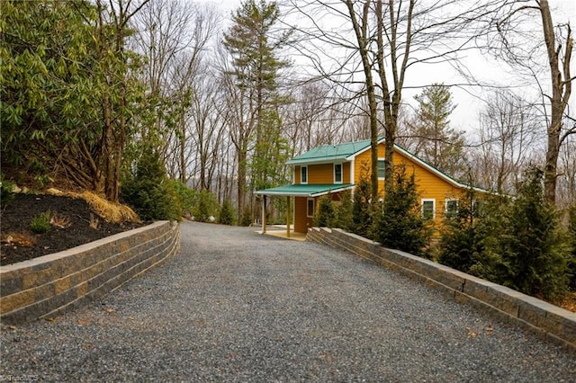 exterior space featuring driveway and metal roof