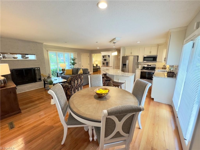 1604 E Fairfield Dr, Mount Airy, NC 27030 - dining space featuring a fireplace, light wood-type flooring, and recessed lighting