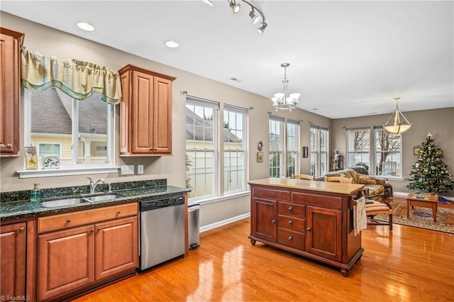 kitchen featuring dishwasher, light hardwood / wood-style floors, sink, and decorative light fixtures