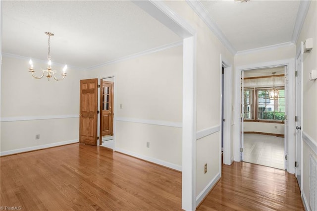 1113 Smokewood Dr, Apex, NC 27502 - empty room featuring a chandelier, wood finished floors, ornamental molding, and baseboards