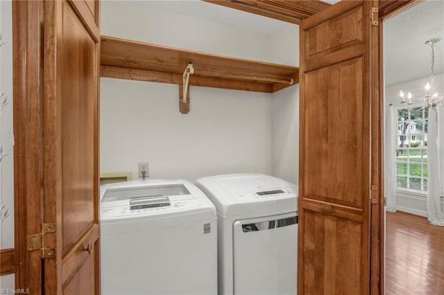 1113 Smokewood Dr, Apex, NC 27502 - laundry area featuring washing machine and dryer, a chandelier, and wood finished floors