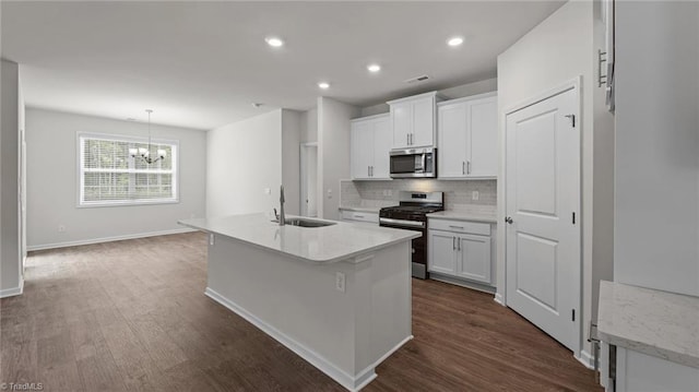 kitchen featuring stainless steel appliances, sink, dark hardwood / wood-style floors, an island with sink, and white cabinets