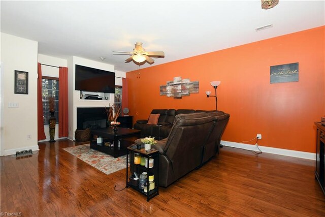 living room featuring dark hardwood / wood-style flooring and ceiling fan