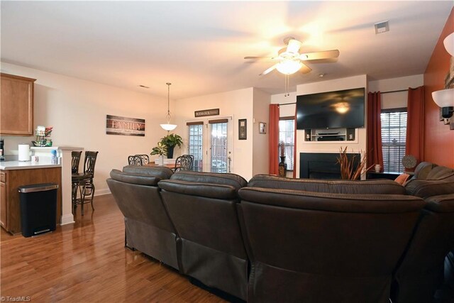 living room featuring a wealth of natural light, light hardwood / wood-style flooring, and ceiling fan