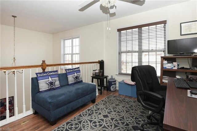 office featuring hardwood / wood-style floors, ceiling fan with notable chandelier, and a healthy amount of sunlight