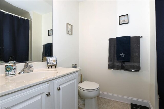 bathroom featuring vanity, tile patterned floors, and toilet