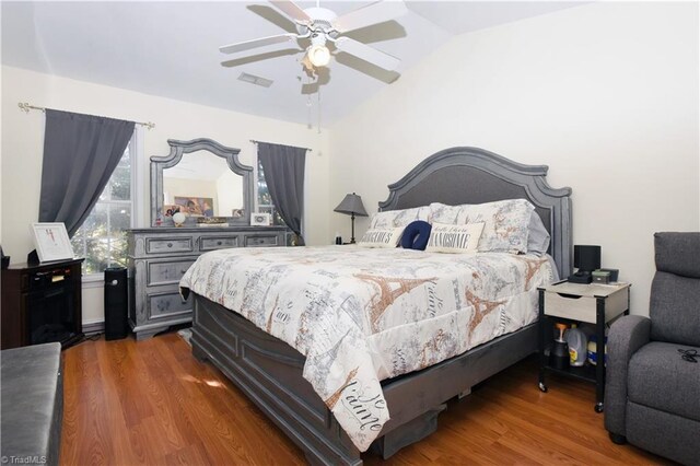 bedroom featuring dark hardwood / wood-style flooring, vaulted ceiling, and ceiling fan